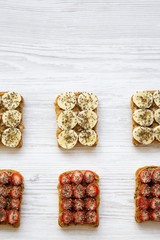Toasts with peanut butter, fruits and chia seeds on a white wooden background, view from above. Healthy breakfast, dieting concept. Copy space.