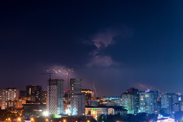 Fototapeta premium Thunder, lighting and storm in dark night sky above city