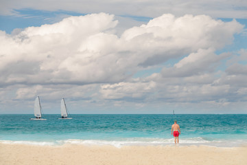 Man in red shorts looks out onto the tropical water. Paradise vacation in the tropics. 