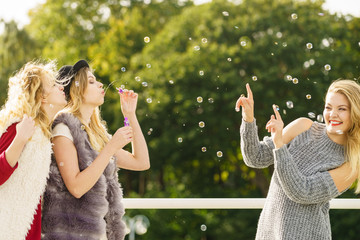 Women friends blowing soap bubbles.