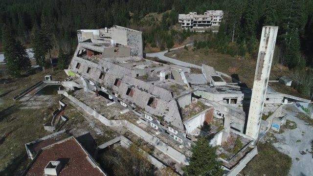 Tilting drone shot of abandoned ruins of luxury resort hotel, part of 1984 Sarajevo Olympic games in former Yugoslavia