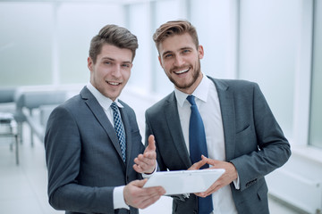 smiling business partners with digital tablet