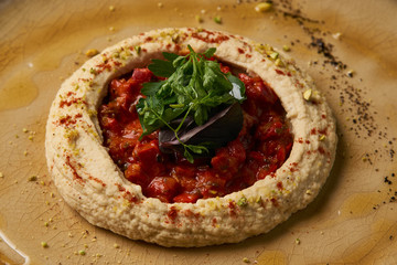 Vegetarian Hummus with harissa sauce and pistachios, close-up, top view