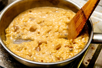 Preparation of risotto with mushrooms in the restaurant kitchen.