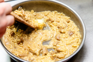 Preparation of risotto with mushrooms in the restaurant kitchen.