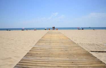 Fototapeta na wymiar Cádiz, Spain - June 21, 2018: Beach line with bathers in Cadiz.