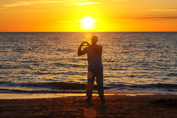 a man enjoys life on the beach at sunset