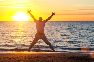 Fototapeta na wymiar a man enjoys life on the beach at sunset