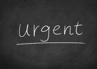 Obraz premium urgent concept word on a blackboard background