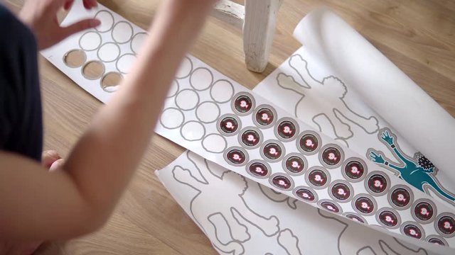 paste the stickers from the paper and stick them on the bottle. against the wood floor and chair.