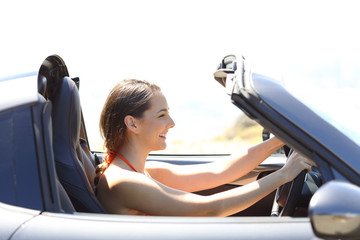 Woman driving a convertible car on summer vacation