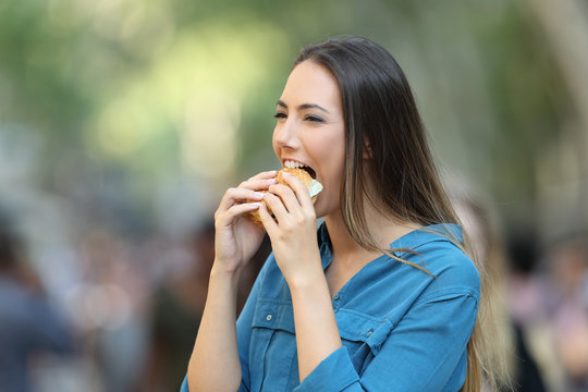 Woman eating a burger on the street