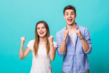 Young couple scream gesture of win isolated on mint background