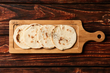 Pita bread on wooden cutting board. Corn tortilla bread on rustic wooden table