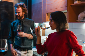 Young woman and man drinking wine on home party