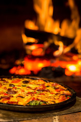 Pizza Oven Pizza shallow depth of field with fire burning in background