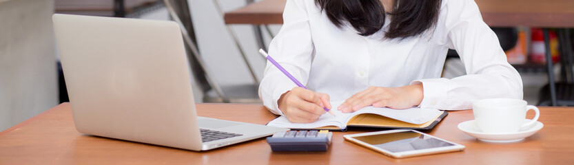 Closeup banner asian woman writing on notebook on table with laptop, girl work at coffee shop,...