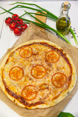 appetizing pizza margarita with olive oil on a white table