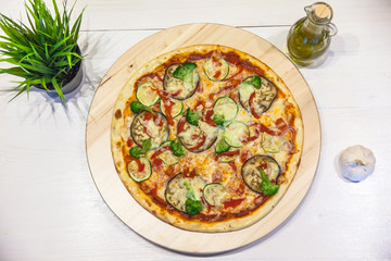 appetizing vegetarian pizza with olive oil on a white table, flat lay