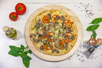 appetizing vegetarian pizza with olive oil, spices and basil leaves on a white table, flat lay