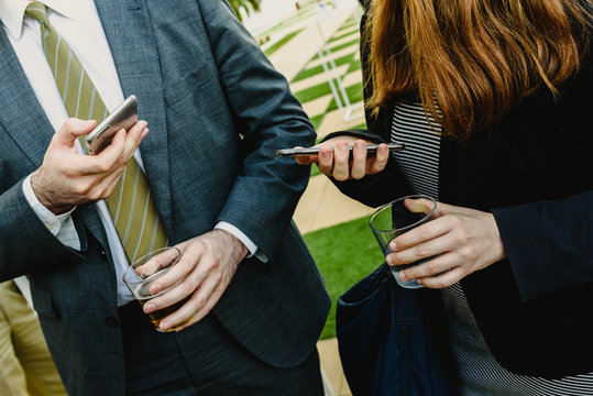 Guest Drinks For A Cocktail At A Business Event And Holding Mobile Phone