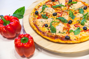 appetizing pizza with salmon, olives and rucola on white table