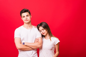 Happy couple embracing and looking camera on red background