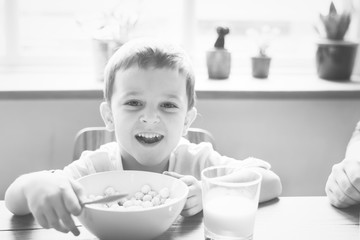 Little boy smiling while eating his breakfast