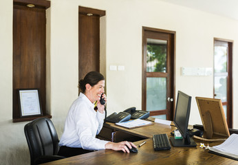 Female resort receptionist working at the front desk