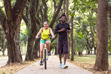 Multiracial couple is training together in wooded area.