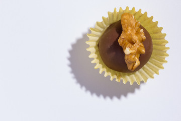 Homemade chocolate truffle. Known as Camafeu in Brazil. Flat lay of candy ball on white table.