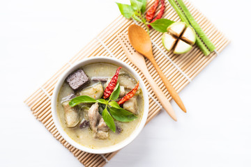 Green curry chicken (Kang Keaw Wan Gai) in a bowl with ingredients, top view, Thai food