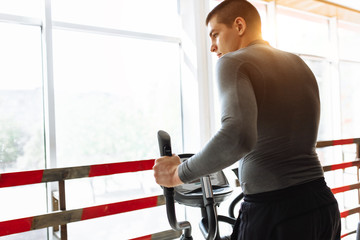 Obraz na płótnie Canvas a man engaged in training on a sports bike in the gym, morning training