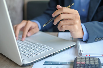 Businessman using laptop for analysis maketing plan, Manager calculate financial report and graph chart.  Business, Finance and Accounting concepts