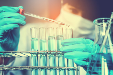 Scientist with equipment holding tools during scientific experiment science concept