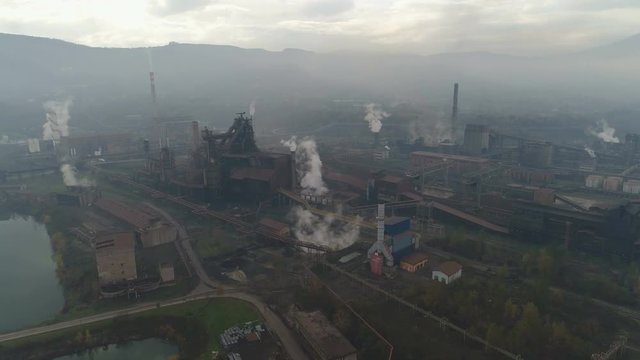 Flying over old rusty steel manufacturing production plant, heavy industry and environmental degradation in Zenica, Bosnia, Europe