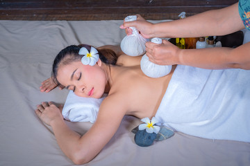 Portrait of young beautiful woman getting massage in spa environment, Traditional oriental aroma...
