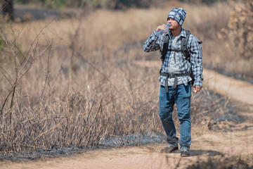 Traveler man drinking water in the forest.