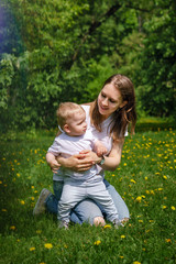 Naklejka na ściany i meble Family. Mom and son are walking in meadow. Girl kneels and hugs little boy.