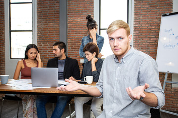 Man feeling unhappy and confuse to work with team. Team connot work with him.