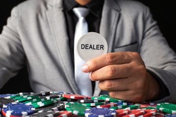 Businessman holding deaker coin isolated on black. Casino and Broker concept.