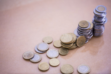 Mortgage loan and real estate tax macro financial Concept, Scandinavian house model and pile of coins money on brown wooden frame, with copy space in middle of the frame.