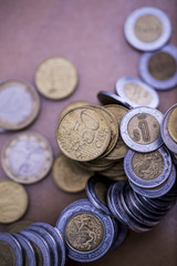 Mortgage loan and real estate tax macro financial Concept, Scandinavian house model and pile of coins money on brown wooden frame, with copy space in middle of the frame.