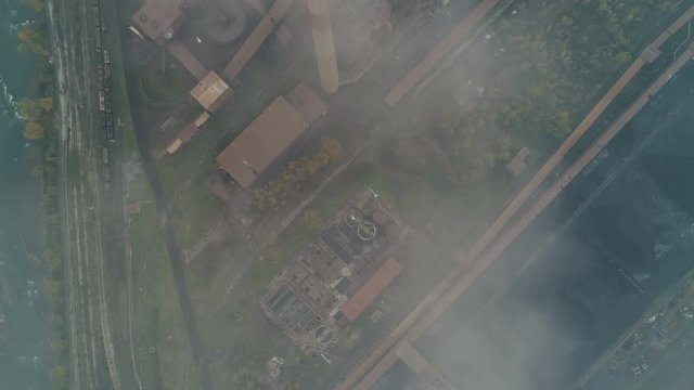 Overhead aerial view of chimneys of rusty steel factory billowing smoke in Zenica, Bosnia and Herzegovina