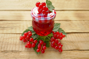 red currant jam and  ripe red currant on a wooden background. Berry season. Currant crop
