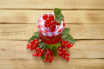 red currant jam and fresh ripe red currant on a wooden background. Berry season. Currant crop