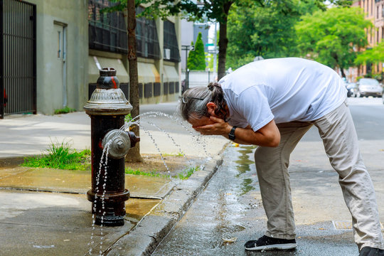 Man during a strong heat temperature is refreshed with Fire hydrant water