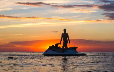 silhouette of a man on a jet ski in the sun © Wingedbull