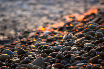pebble stones on the sea beach, the rolling waves of the sea with foam © Wingedbull