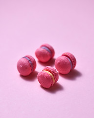 pink mini macarons on pink paper background with copy space